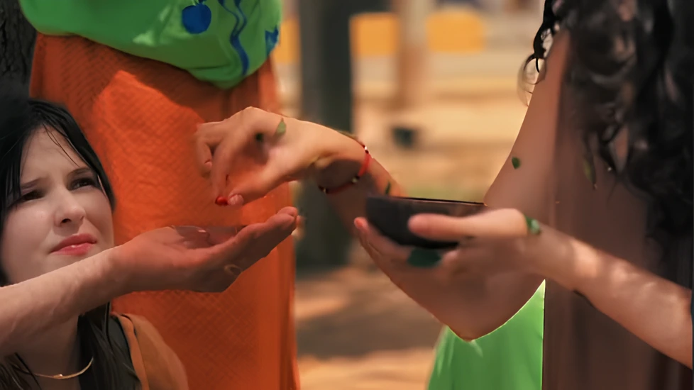 Oficina de Yasmin Formiga onde entrega uma semente na mão de outra pessoa, com uma garota observando de fundo