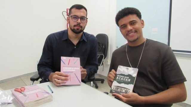 Autores José Hewerton e Ádrio Debray segurando livros que lançaram em um evento na UFCG, campus Cajazeiras.